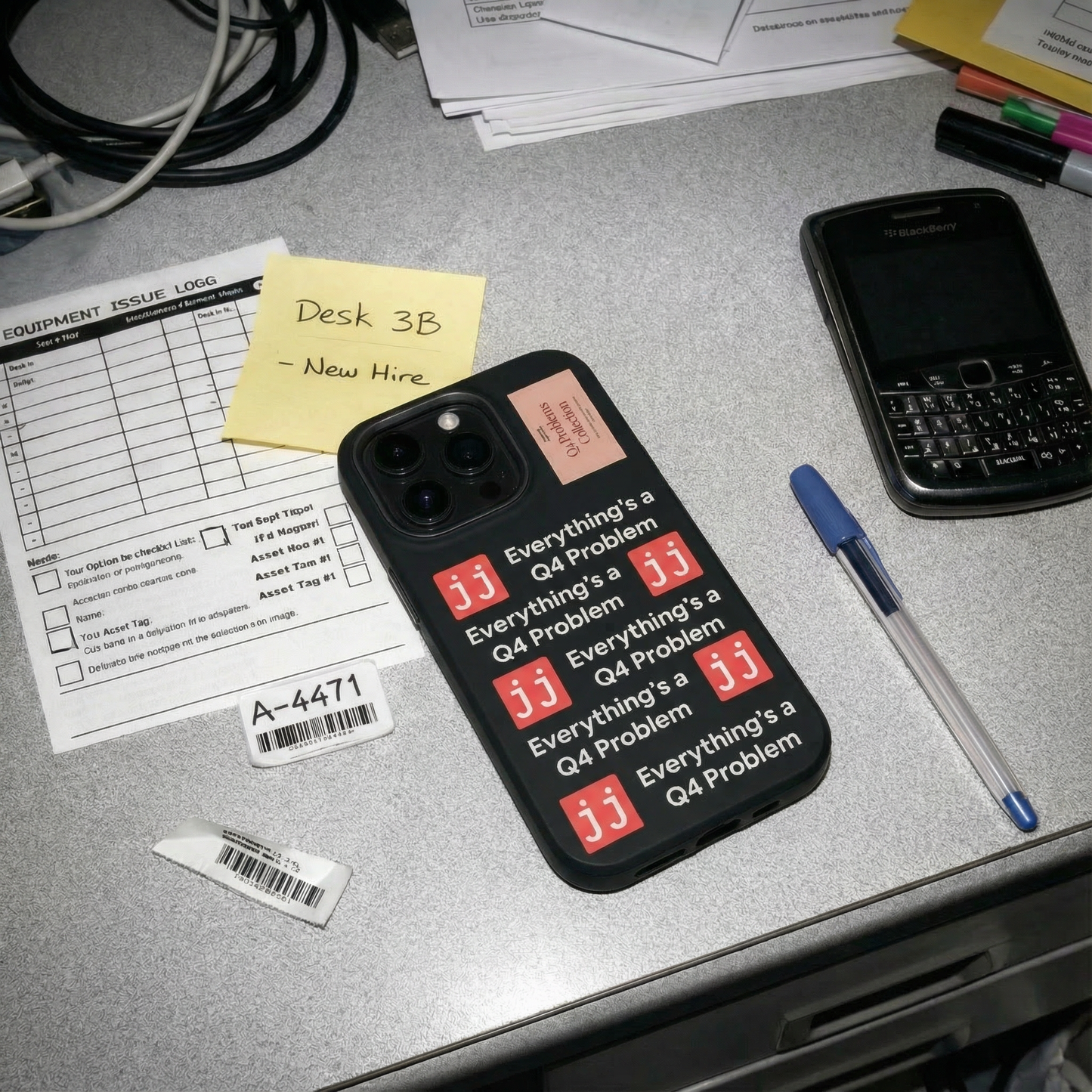 Everything’s a Q4 Problem' phone case on a desk with an equipment issue log, vintage BlackBerry, and New Hire note.