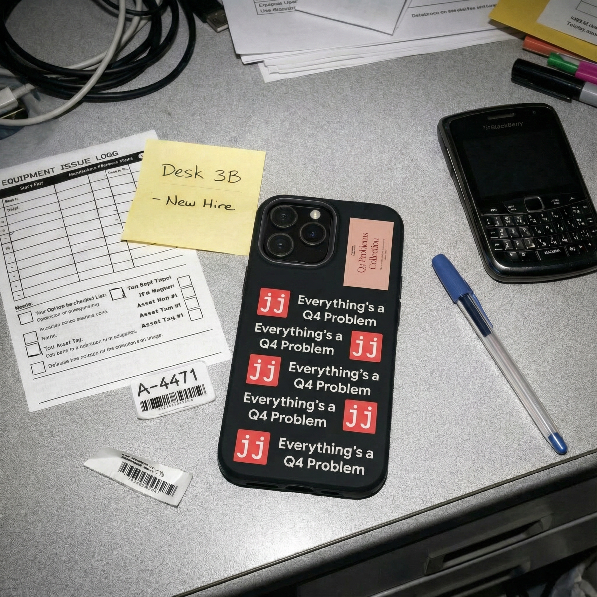 Everything’s a Q4 Problem' phone case on a desk with an equipment issue log, vintage BlackBerry, and New Hire note.