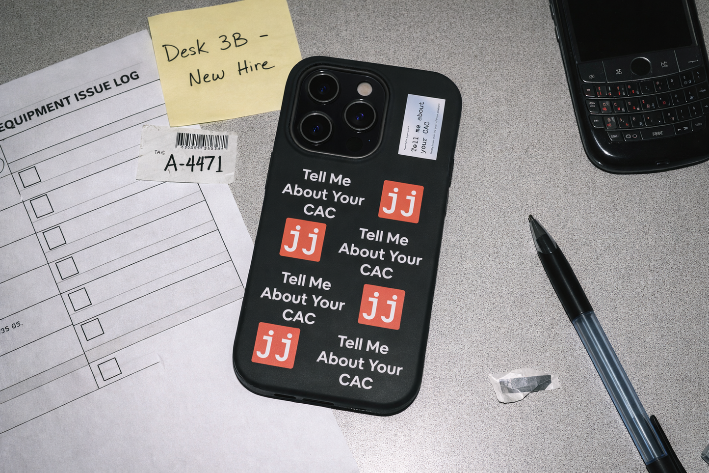 Jargon Junkie black iPhone 14 Pro case with Tell Me About Your CAC text and JJ logos on office desk with equipment issue log corporate humor phone accessory