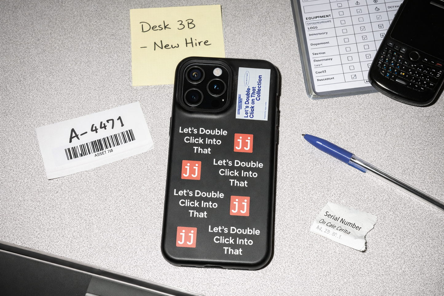 Jargon Junkie black iPhone 15 Pro Max case with Let's Double Click Into That text and JJ logos on office desk with equipment issue log corporate humor phone accessory
