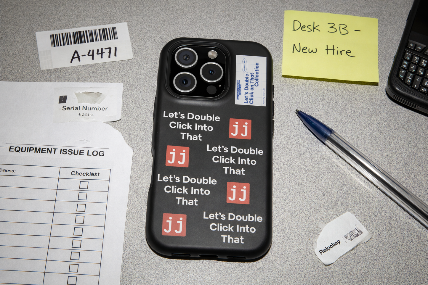 Jargon Junkie black iPhone 16 Pro case with Let's Double Click Into That text and JJ logos on office desk with equipment issue log corporate humor phone accessory