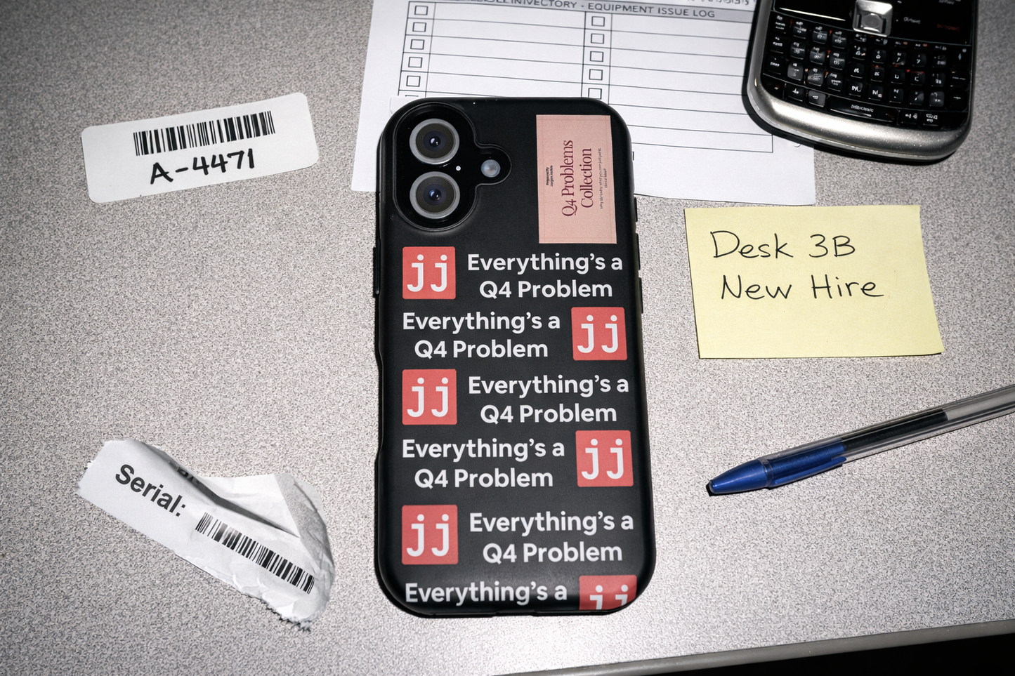 Everything’s a Q4 Problem' phone case on a desk with an equipment issue log, vintage BlackBerry, and New Hire note.