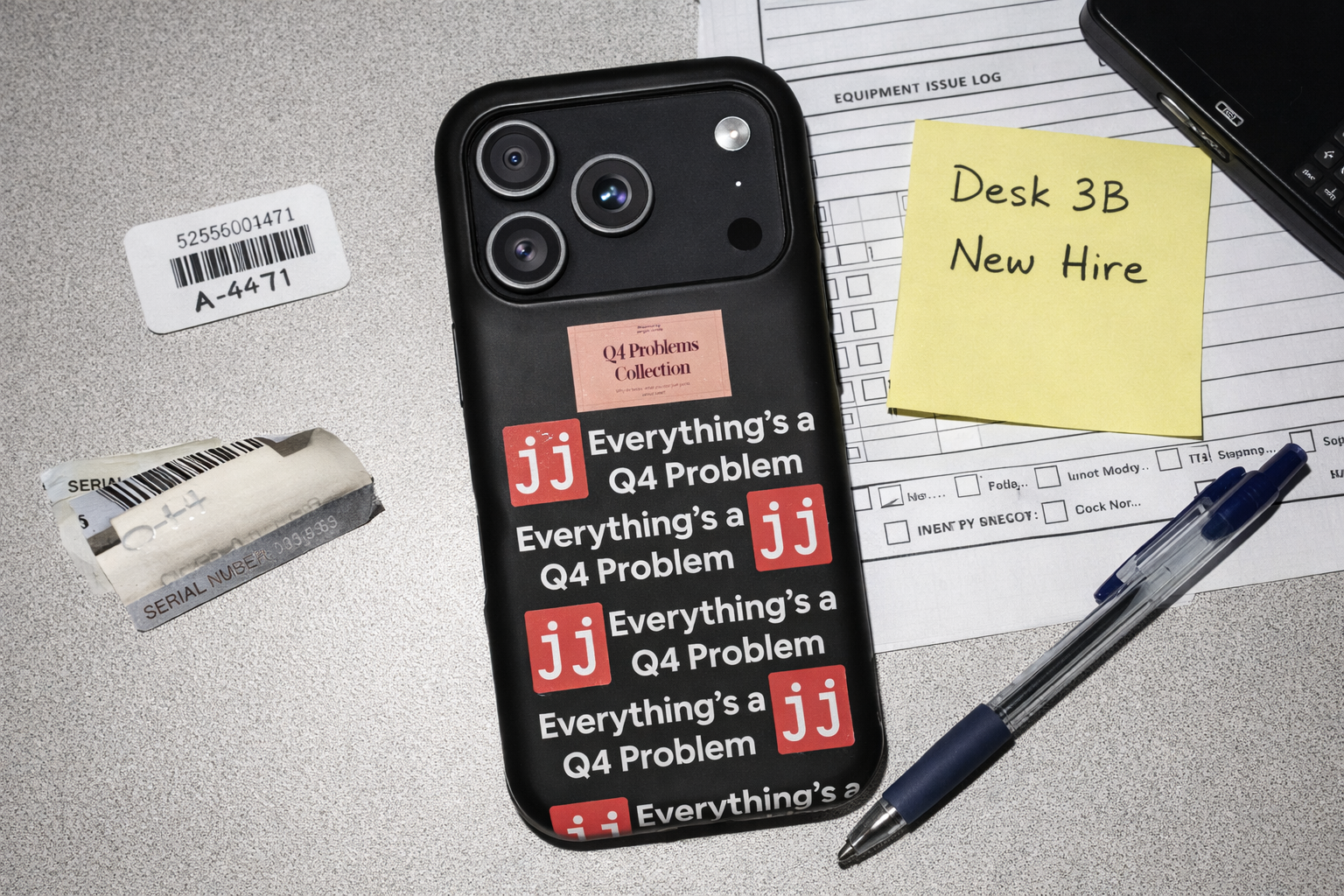 Everything’s a Q4 Problem' phone case on a desk with an equipment issue log, vintage BlackBerry, and New Hire note.