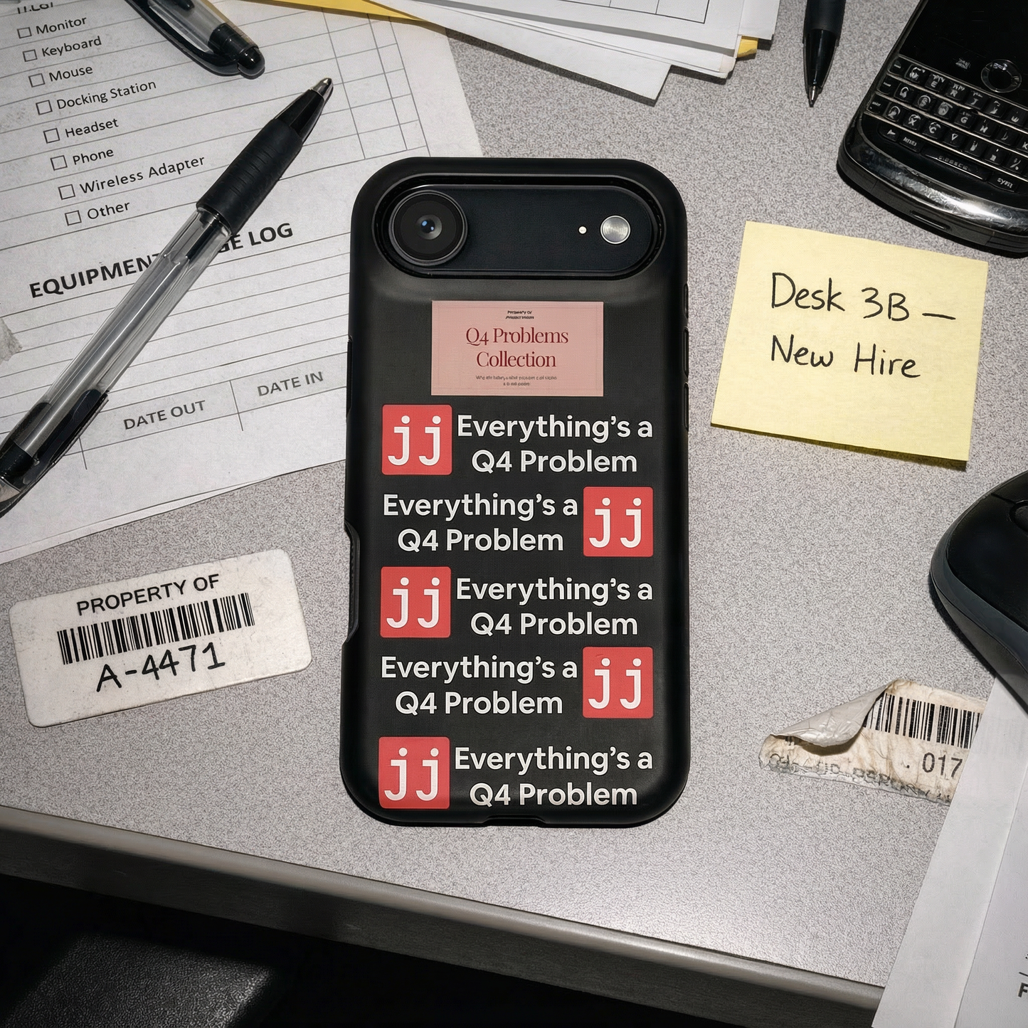 Everything’s a Q4 Problem' phone case on a desk with an equipment issue log, vintage BlackBerry, and New Hire note.